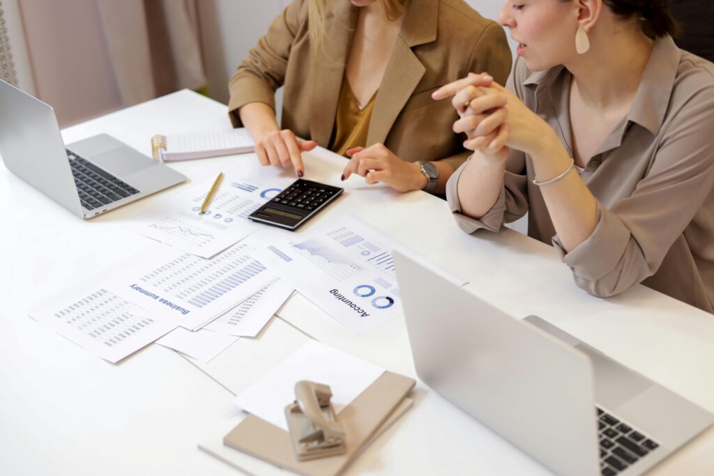 pexels-photo-6779716-6779716 Two professionals collaborating on financial documents in a modern office setting.
